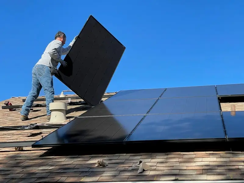 Technicien Serena Energy nettoyant des panneaux solaires photovoltaïques avec une perche télescopique en Occitanie